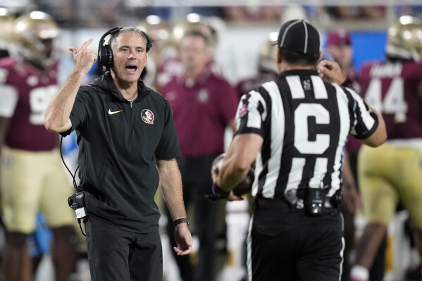 Florida State head coach Mike Norvell, left, has words with center judge Brian Alos during the first half of an NCAA college football game against LSU, Sunday, Sept. 3, 2023, in Orlando, Fla. (AP Photo/John Raoux)
