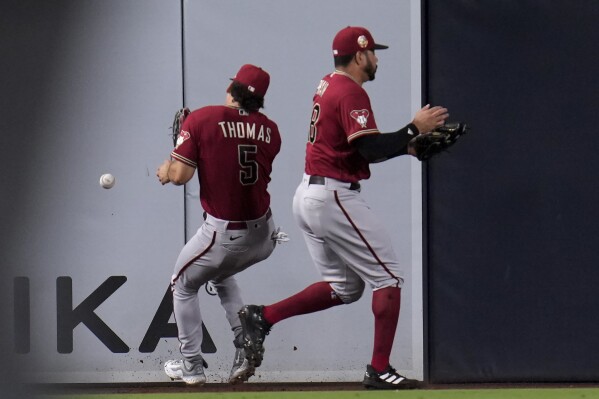Arizona Diamondbacks center fielder Alek Thomas (5) can't make the catch on a double hit by San Diego Padres' Jake Cronenworth as he nearly collides with left fielder Tommy Pham during the fifth inning of a baseball game Thursday, Aug. 17, 2023, in San Diego. (AP Photo/Gregory Bull)
