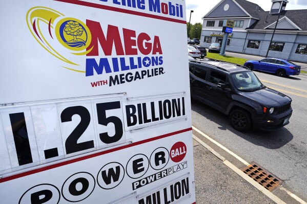 Cars pass a sign showing the expected $1.25 billion jackpot of Friday night's Mega Millions lottery drawing, outside Ted's State Line Mobil, Thursday, Aug. 3, 2023, in Methuen, Mass. The game has not had a winner since mid-April. (AP Photo/Charles Krupa)