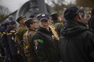 Decorated State Emergency Service units member Anna Pinchuk attends a ceremony commemorating the Chernobyl nuclear power plant disaster, at the Those Who Saved the World monument in Chernobyl, Ukraine, Tuesday, April 26, 2022. (AP Photo/Francisco Seco)