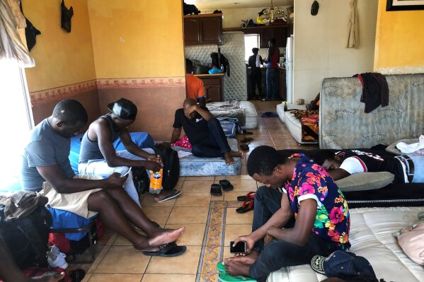 FILE - In this July 28, 2019, file photo, Cameroonians wait in a rented apartment in Tijuana, Mexico, until their names are called to claim asylum in the U.S.  President Donald Trump isn't the only world leader making it virtually impossible for many Africans to get asylum in the United States.  Ecuador is closing its doors as one of the few countries in North and South America to welcome African visitors, depriving them of a starting point for their dangerous journeys north by land.  (AP Photo/Elliot Spagat, File)