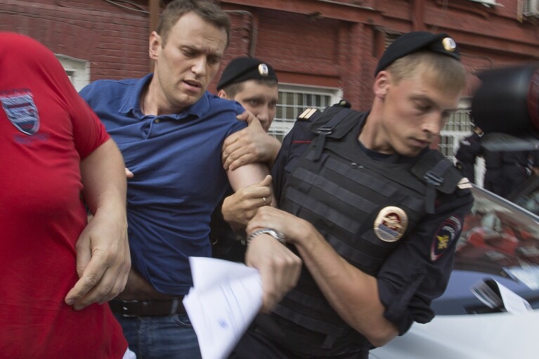 FILE - Police officers detain Russian opposition leader Alexei Navalny, left, in Moscow on July 10, 2013. Russia’s prison agency says that imprisoned opposition leader Alexei Navalny has died. He was 47. The Federal Prison Service said in a statement that Navalny felt unwell after a walk on Friday Feb. 16, 2024 and lost consciousness. (AP Photo/Alexander Zemlianichenko, File)