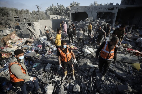 Palestinians inspect the damage of a destroyed house following Israeli airstrikes on Khan Younis, Southern Gaza Strip, Sunday, Dec. 31, 2023. (AP Photo/Mohammed Dahman)