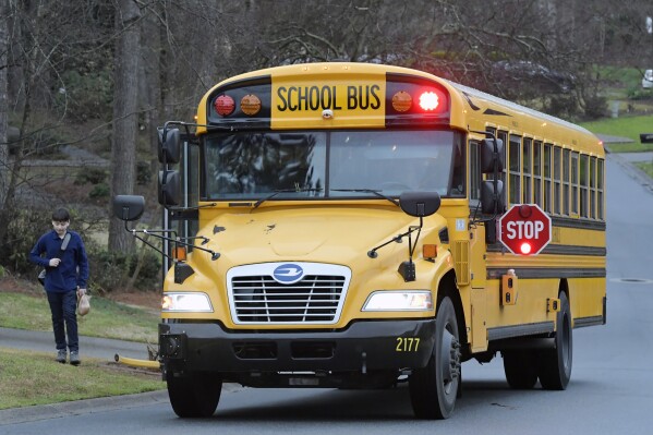 FILE - A Cobb County School bus moves down a street on Friday, March 13, 2020, in Kennesaw, Ga. A federal judge ruled on Thursday, Dec. 14, 2023 that school board district lines in Georgia's second-largest school system appear to be illegally discriminating against Black and Hispanic voters. (AP Photo/Mike Stewart, File)
