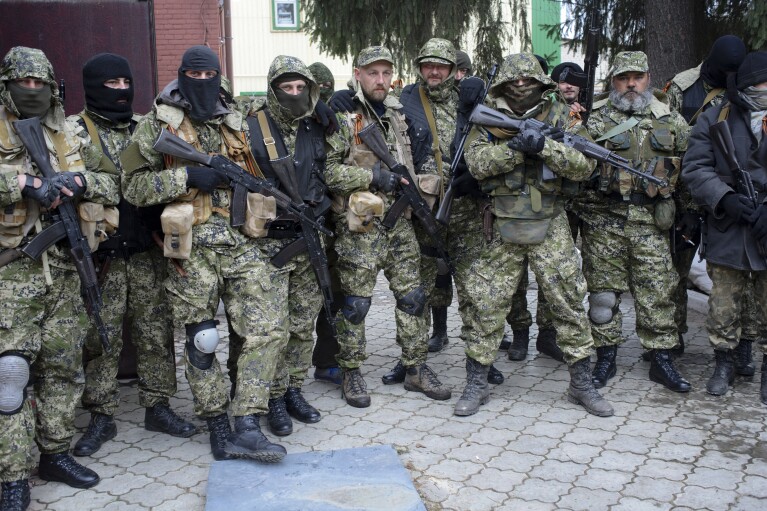 FILE - Armed pro-Russian activists pose for a photo after they occupied a police station in the eastern town of Slovyansk, Ukraine, on Saturday, April 12, 2014. The Kremlin threw its weight behind separatist rebels in the east, triggering eight years of hostilities that set the stage for Moscow to send troops into Ukraine in February 2022. (AP Photo/Maxim Dondyuk, Russian Reporter magazine, File) MAGAZINES OUT