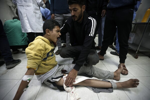 A Palestinian boy wounded in Israeli airstrikes on a U.N.-run school receives treatment at the Nasser hospital in the town of Khan Younis, southern Gaza Strip. Saturday, Dec. 17, 2023. (AP Photo/Mohammed Dahman)