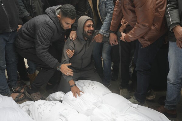Palestinians mourn relatives killed in the Israeli bombardments of the Gaza Strip in front of the morgue of the Al Aqsa Hospital in Deir al Balah, Gaza Strip, on Thursday, March 7, 2024. (AP Photo/Adel Hana)