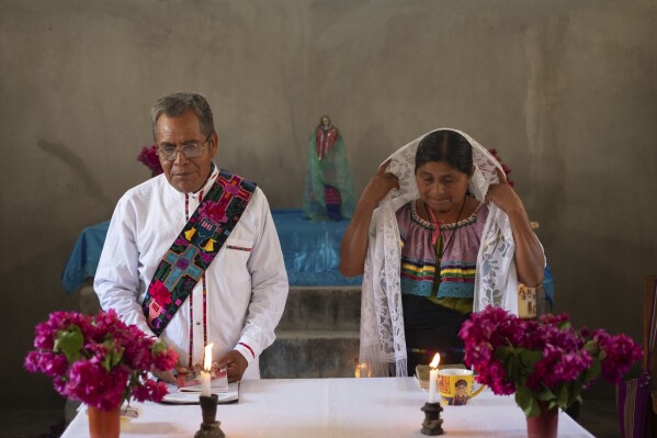 Deacon Juan Pérez Gómez, accompanied by his wife Crecencia López, stands at the altar during a Mass honoring the late Pope Francis, in Simojovel, Mexico, April 27, 2025. (AP Photo/Isabel Mateos, File)