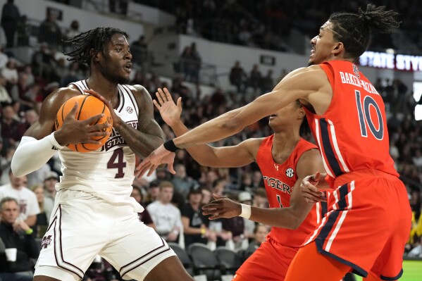 Mississippi State forward Cameron Matthews (4) protects the ball from Auburn guard Chad Baker-Mazara (10) during the first half of an NCAA college basketball game, Saturday, Jan. 27, 2024, in Starkville, Miss. (AP Photo/Rogelio V. Solis)