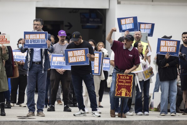 Demonstrators gather during a protest against new travel ban announced last week by President Donald Trump, at the Tom Bradley International Terminal at Los Angeles International Airport, Monday, June 9, 2025, in Los Angeles. (AP Photo/Etienne Laurent)