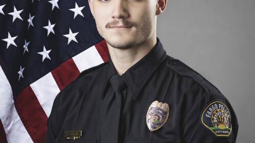 This photo provided by The City of Fargo, N.D., on Saturday, July 15, 2023 shows police officer Jake Wallin. On Saturday, Fargo's police chief said a gunman opened fire on police and firefighters as they responded to a traffic crash in North Dakota. One officer, Wallin, was killed and two others were wounded before a fourth officer killed him. (The City of Fargo via AP)