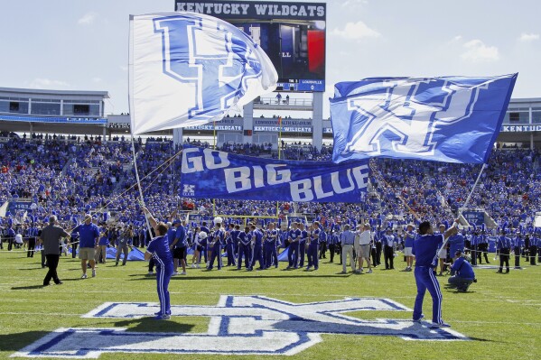 Kentucky players and cheerleaders take the field before an NCAA college football game against Louisville on Saturday, Sept. 14, 2013, in Lexington, Ky. (AP Photo/James Crisp, File)
