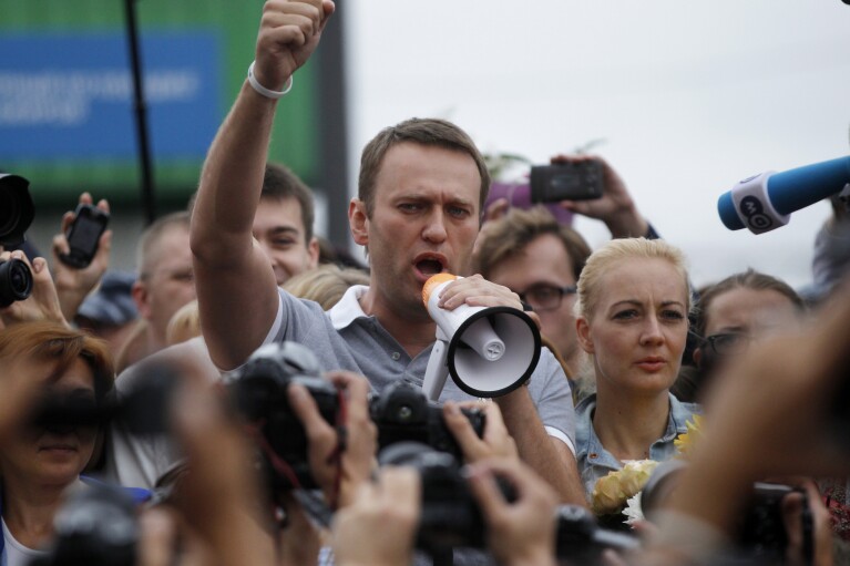 Russian opposition leader Alexei Navalny, center, addresses supporters and journalists after arriving from Kirov at a railway station in Moscow, Russia, Saturday, July 20, 2013. (AP Photo/ Dmitry Lovetsky, File)