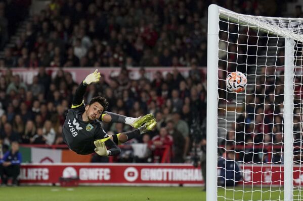 Burnley goalkeeper James Trafford dives in vain as Nottingham Forest's Callum Hudson-Odoi scores during the English Premier League soccer match between Burnley and Nottingham Forest at City Ground, Nottingham, England, Monday Sept. 18, 2023. (Tim Goode/PA via AP)