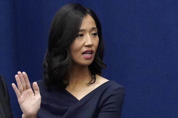 Michelle Wu raises her hand as she is sworn-in as Boston Mayor during a ceremony at Boston City Hall, Tuesday, Nov. 16, 2021, in Boston. The election of Wu marked the first time that Boston voters elected a woman, or a person of color, to lead the city.   (AP Photo/Charles Krupa)