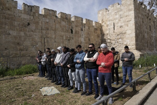 Palestinian Muslims pray outside of the walls of the Old City of Jerusalem after Israeli police denied their entry to the Al-Aqsa Mosque compound for Friday prayers, Friday, March 1, 2024. (AP Photo/Mahmoud Illean)