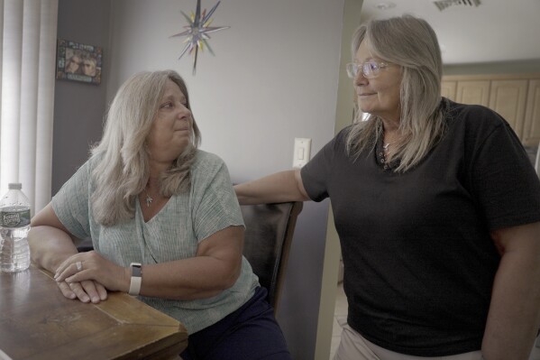 Mary Miller-Duffy, left, sits next to her wife, Sue Duffy, in their home in Newburgh, N.Y., on Aug. 2, 2023. Research with her brother-in-law's body has changed Sue's outlook on organ donation. “Maybe I don’t need all my organs when I go to heaven,” she says. “Before I was a hard no. ... Now I’m a hard yes.” (AP Photo/Shelby Lum)