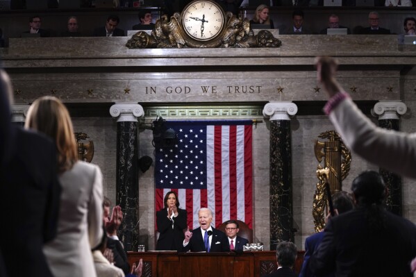 President Joe Biden delivers the State of the Union address to a joint session of Congress at the Capitol, Thursday, March 7, 2024, in Washington. Standing at left is Vice President Kamala Harris and seated at right is House Speaker Mike Johnson, R-La. (Shawn Thew/Pool via AP)