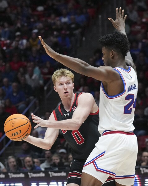 Utah guard Hunter Erickson (0) passes around Kansas forward KJ Adams Jr. (24) during the second half of an NCAA college basketball game, Saturday, Feb. 15, 2025, in Salt Lake City. (AP Photo/Bethany Baker)