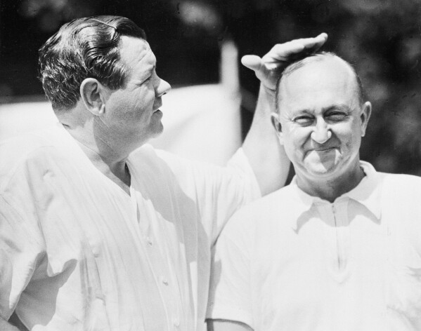 Babe Ruth pats Ty Cobb on the head after their second golf match at Fresh Meadow Country Club in New York on June 27, 1941.  The two baseball players are playing a charity grudge tournament with proceeds going to the United Service Organizations.  Ruth won today's match and Cobb won the first match held in Boston, July 26.  (AP Photo)