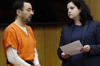 Former sports doctor Larry Nassar, left, stands with his attorney Shannon Smith as he pleads guilty to three counts of first-degree criminal sexual conduct Wednesday, Nov. 29, 2017, in Judge Janice Cunningham's courtroom in Eaton County, Mich. (Matthew Dae /Lansing State Journal via AP)