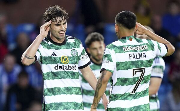 Celtic's Matt O'Riley, left, celebrates with Adam Idah after scoring their side's fifth goal of the game during the Scottish Premier League soccer match between Celtic Glasgow and Kilmarnock at The BBSP Stadium Rugby Park, in Kilmarnock, Wednesday May 15, 2024. (Jane Barlow/PA via AP)