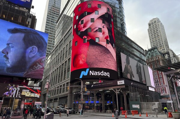 Pedestrians walk past the Nasdaq building in New York on Tuesday, March 26, 2024. Donald Trump’s social media company begins trading publicly Tuesday. Trump Media & Technology Group Corp. was acquired Monday by a blank-check company called Digital World Acquisition Corp. Trump Media, which runs the social media platform Truth Social, now takes Digital World’s place on the Nasdaq stock exchange. (AP Photo/Peter Morgan)