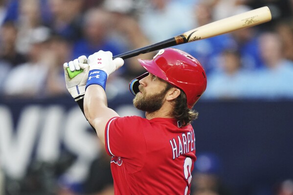 Philadelphia Phillies' Bryce Harper watches his solo home run against the Toronto Blue Jays during the third inning of a baseball game Wednesday, Aug. 16, 2023, in Toronto. (Nathan Denette/The Canadian Press via AP)
