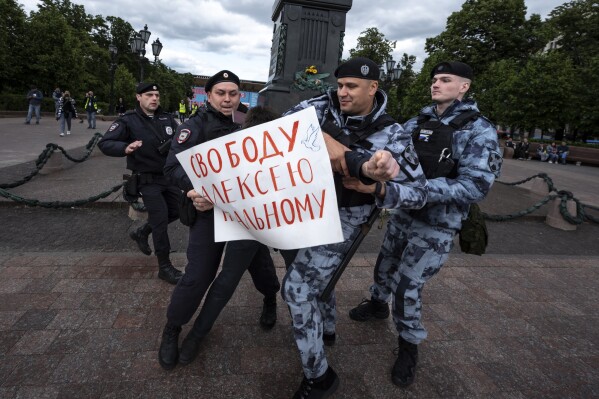 FILE - Police officers detains a demonstrator with a poster that reads: "Freedom for Alexei Navalny,” in Pushkinskaya Square in Moscow on Sunday, June 4, 2023. In the last two years, ordinary Russians have been increasingly swept up in an unprecedented government crackdown, together with opposition politicians, independent journalists and human rights activists. (AP Photo, File)