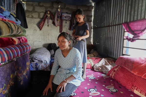 Nirmala Pariyar's sister braids her hair at her home in Kathmandu, Nepal on Tuesday, April 1, 2025 (AP Photo/Niranjan Shrestha)