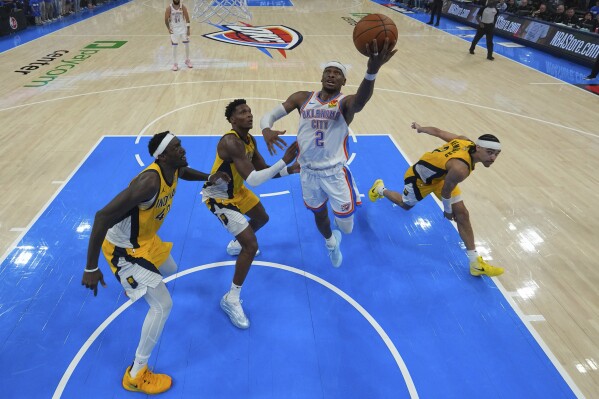 Oklahoma City Thunder guard Shai Gilgeous-Alexander (2) shoots past Indiana Pacers forward Pascal Siakam, left, and Indiana Pacers guard Andrew Nembhard, right, during the second half of Game 5 of the NBA Finals basketball series, Monday, June 16, 2025, in Oklahoma City. (AP Photo/Nate Billings)
