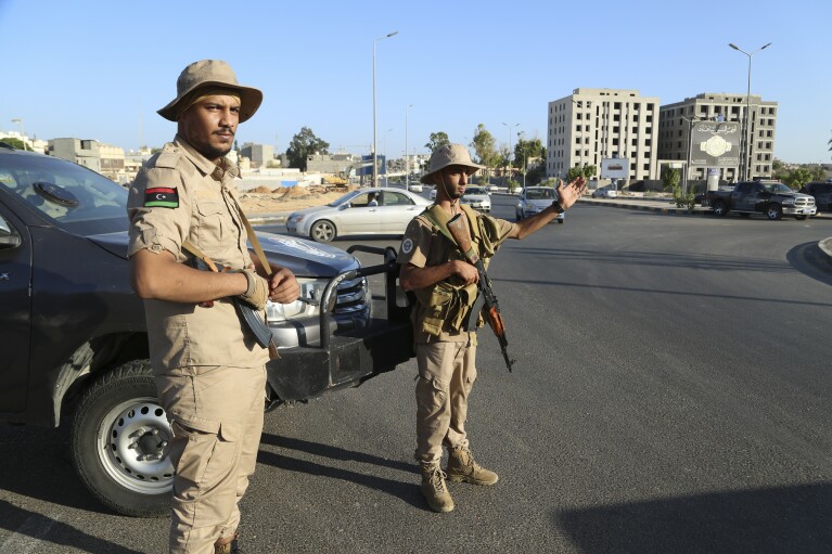 Libyan security forces stand guard in Tripoli, Libya, Tuesday, Aug. 16, 2023. Clashes between rival militias in Libya's capital killed a few dozen people and left residents trapped in their homes Tuesday, unable to escape the violence, medical authorities said. (AP Photo/Yousef Murad)