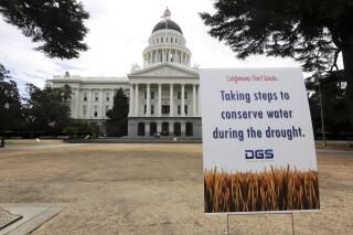 FILE - In this July 8, 2014, file photo, is a sign alerting visitors to water conservation effort...