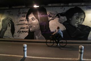 FILE - A woman rides bicycle front of a mural signed by Clacks-one and Heartcraft_Street art, depicting women cutting their hair to show support for Iranian protesters standing up to their leadership over the death of a young woman in police custody, in a tunnel in Paris, France, Wednesday, Oct. 5, 2022. The mother of a 16-year-old Iranian girl has disputed official claims, Friday, Oct. 7,  that her daughter fell to her death from a high building, saying the teen was killed by blows to the head as part of the crackdown on anti-hijab protests roiling the country.  Nika Shakarami has become the latest icon of the protests, seen as the gravest threat to Iran’s ruling elites in years.  (AP Photo/Francois Mori)