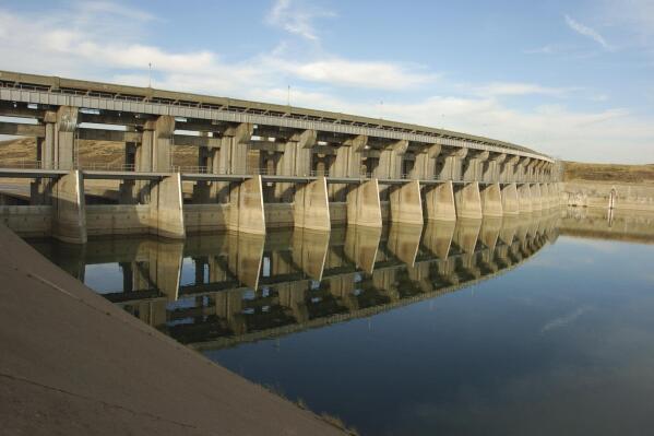 FILE - This April 23, 2012 file photo shows the Fort Peck Dam spillway in northeast Montana. Federal officials plan to increase water releases through the dam to help an endangered fish, pallid sturgeon. (AP Photo/Matt Brown,File)