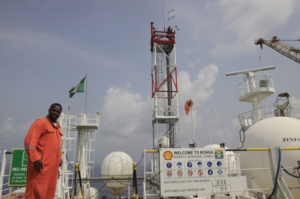 FILE - A member of Shell staff on the Bonga offshore oil Floating Production Storage and Offloading vessel off the coast of the Niger Delta in Nigeria, on Dec. 26, 2011. Local activists and international environmental groups want Nigeria's government to delay approving the sale of oil company Shell's onshore assets, claiming Shell is trying to shirk its environmental and social responsibilities in the highly polluted Niger Delta. The Centre for Research on Multinational Corporations (SOMO), a Dutch non-profit, released a report Wednesday Feb. 28, 2024 saying Shell shouldn’t be allowed to divest in the delta unless it takes “responsibility for its toxic legacy of pollution and ensures the safe decommissioning of abandoned oil infrastructure.” (AP Photo/Sunday Alamba, File)