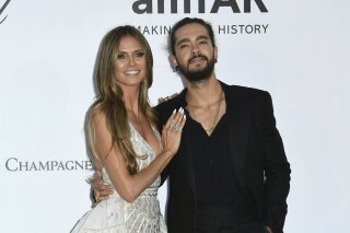 FILE - In this May 17, 2018, file photo, model Heidi Klum, left, and musician Tom Kaulitz pose for photographers upon arrival at the amfAR, Cinema Against AIDS, benefit at the Hotel du Cap-Eden-Roc, during the 71st international Cannes film festival, in Cap d'Antibes, southern France. Klum, a 45-year-old German model, announced her engagement to Tokio Hotel guitarist Kaulitz in an Instagram post on Monday, Dec. 24. (Photo by Arthur Mola/Invision/AP, File)