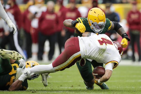 Washington Commanders quarterback Taylor Heinicke (4) throws under pressure  from Green Bay Packers linebacker Rashan Gary (52) during the first half of  an NFL football game Sunday, Oct. 23, 2022, in Landover