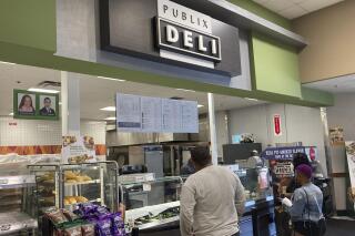 Clients wait to order lunch at the Publix Supermarket Deli in Miami Shores, Fla., Tuesday April 27, 2021. A popular Twitter account that notified people when Publix chicken-tender subs were on sale has been abandoned after lawyers for the Florida-based grocery chain apparently objected. The account "Are Publix Chicken Tender Subs On Sale?" – with nearly 40,000 followers – has been dormant since March 11. (AP Photo/Marta Lavandier)