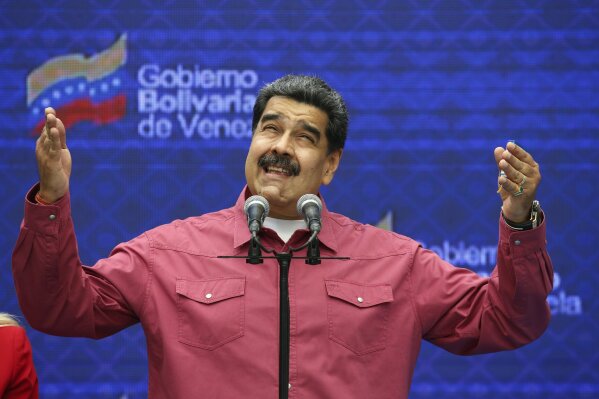 Venezuela's President Nicolas Maduro talks to journalist covering his vote in elections to choose members of the National Assembly in Caracas, Venezuela, Sunday, Dec. 6, 2020. The vote, championed by Maduro, is rejected as fraud by the nation's most influential opposition politicians. (AP Photo/Ariana Cubillos)
