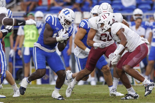 Duke's Jaquez Moore (9) cradles the ball next to Lafayette's Saiku White (11) during the first half of an NCAA college football game in Durham, N.C., Saturday, Sept. 9, 2023. (AP Photo/Ben McKeown)