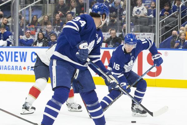 Toronto Maple Leafs Mitchell Marner (16) takes a pass from teammate Auston Matthews (34) during second-period NHL hockey game action against the Florida Panthers in Toronto, Sunday, March 27, 2022. (Chris Young/The Canadian Press via AP)
