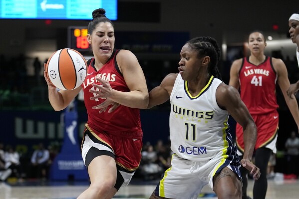 Las Vegas Aces guard Kelsey Plum (10) works for a shot attempt against Dallas Wings guard Crystal Dangerfield (11) during the first half of a WNBA basketball game Tuesday, Aug. 8, 2023, in Arlington, Texas. (AP Photo/Tony Gutierrez)