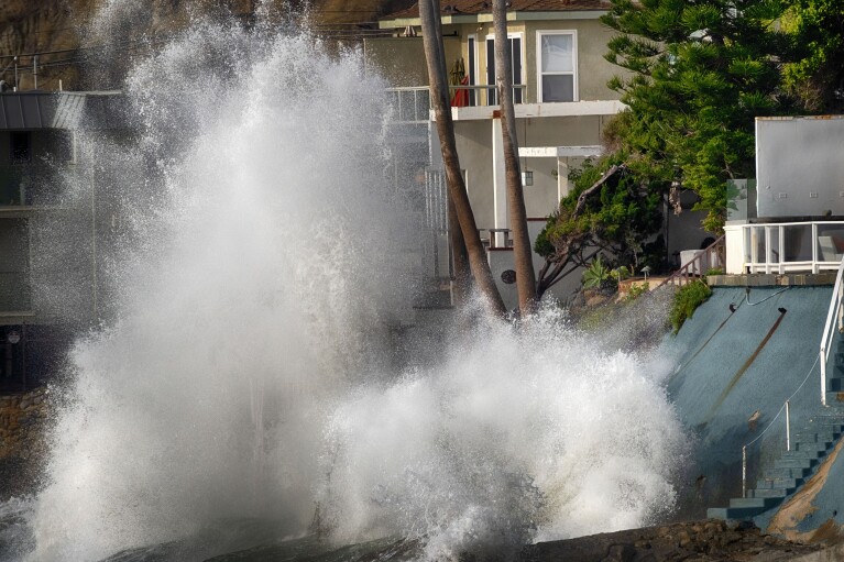 Waves crash against a sea wall next to homes along the California coast on Friday, Dec. 29, 2023, in Malibu Beach, California.  A large swell generated by the stormy Pacific Ocean caused powerful waves on the beaches of the West Coast and Hawaii.  towards coastlines, causing localized flooding.  (AP Photo/Richard Vogel)