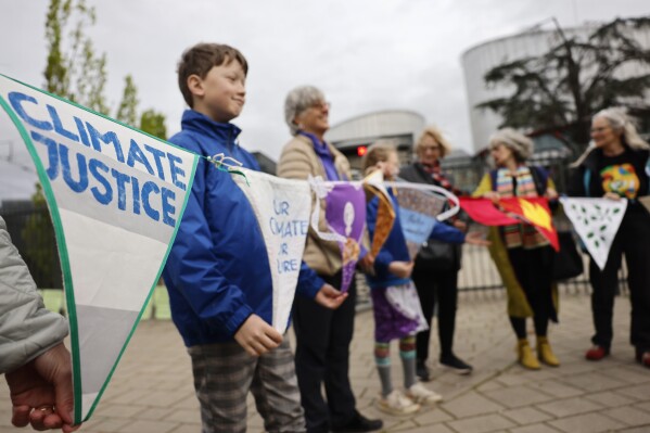 People demonstrate outside the European Court of Human Rights Tuesday, April 9, 2024 in Strasbourg, eastern France. Europe's highest human rights court will rule Tuesday on a group of landmark climate change cases aimed at forcing countries to meet international obligations to reduce greenhouse gas emissions. The European Court of Human Rights will hand down decisions in a trio of cases brought by a French mayor, six Portuguese youngsters and more than 2,000 elderly Swiss women who say their governments are not doing enough to combat climate change. (AP Photo/Jean-Francois Badias)