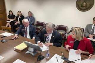 Georgia House Appropriations Committee Chairman Terry England, center, signs his final budget on Monday, April 4, 2022, at the state capitol in Atlanta. England, R-Auburn, is retiring after 12 years as the House's chief budget writer. (AP Photo/Jeff Amy)