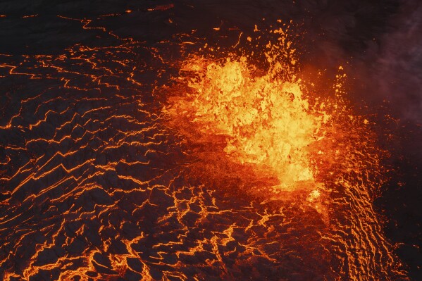 Lava flows from a volcano in Grindavik, Iceland, Wednesday, May 29, 2024. A volcano in southwestern Iceland erupted Wednesday for the fifth time since December, spewing red lava that once again threatened the coastal town of Grindavik and led to the evacuation of the popular Blue Lagoon geothermal spa. (AP Photo/Marco di Marco)