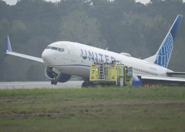 A United Airlines jet sits in a grassy area after leaving the taxiway Friday, March 8, 2024, at George Bush Intercontinental Airport in Houston. No passenger or crew injuries have been reported, according to a United Airlines spokesperson. (Jason Fochtman/Houston Chronicle via AP)