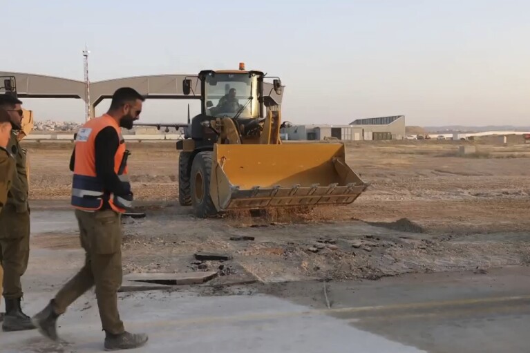 This still from an undated handout video released by the Israeli military shows workers trying to repair a taxiway at Israel's Nevatim air base. An Iranian attack on an Israeli desert air base as part of Tehran's unprecedented assault on the country damaged a taxiway, a satellite image analyzed by The Associated Press on Saturday shows. (Israeli military via AP)