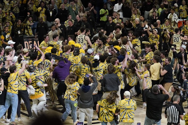 Fans storm the court as they celebrate with Wake Forest players after Wake Forest defeated Duke in an NCAA college basketball game in Winston-Salem, N.C., Saturday, Feb. 24, 2024. (AP Photo/Chuck Burton)